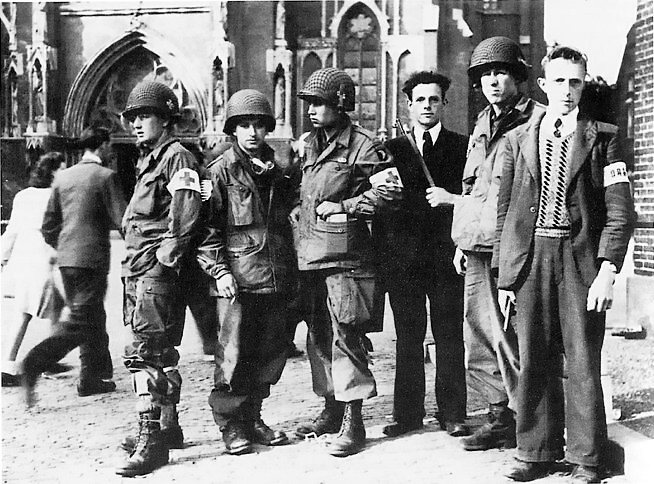 Miembros de la resistencia de Eindhoven de la 326.ª compañía médica (101.ª aerotransportada) delante de la catedral de misma ciudad (septiembre de 1944). Es una imagen de dominio público.